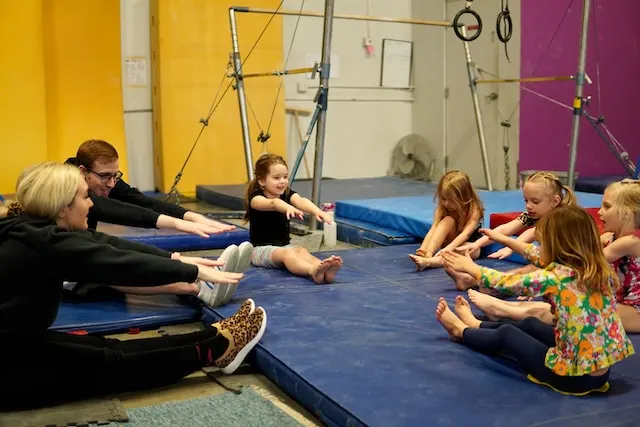 des enfants qui font du sport sous la tutelle d'un coach